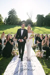 Bride and groom walking back down the aisle as guests applaud, outdoor ceremony in Provence
