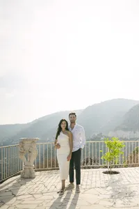 Newly engaged couple standing on a terrace overlooking the hills and the sea in Èze, French Riviera