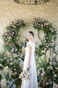 Editorial portrait of a bride in front of a round floral arch