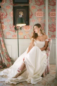 Bride seated in an elegant salon with patterned walls