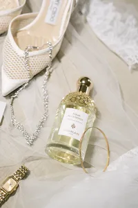 Bridal details with a perfume bottle and jewelry on soft fabric