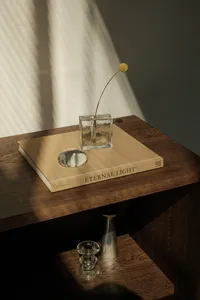 kaboompics_coffee-table-book-and-craspedia-flower-styled-on-dark-wood-43428