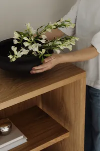 kaboompics_hand-holding-black-ceramic-bowl-with-white-flowers-42642