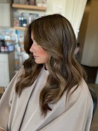 Medium length, brunette highlights with blowout curls at 904 Balayage.