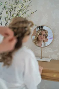 bride getting hair done at wedding