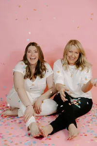 Nicole and Dylan, mother-daughter Salesforce strategists, celebrating with confetti against a pink background.