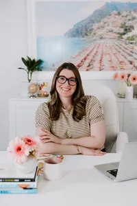 Woman posing professionally at a desk as Salesforce career strategists and mentors.