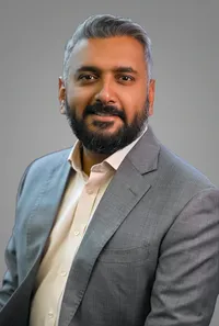 Headshot of an executive in a blazer, serious pose, neutral backdrop