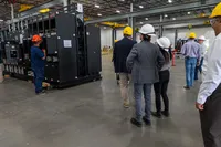 A group of people in hard hats touring a warehouse