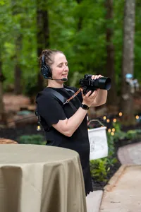 A photographer with a headset on taking a photo
