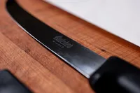 The blade of a knife sitting on a cutting board