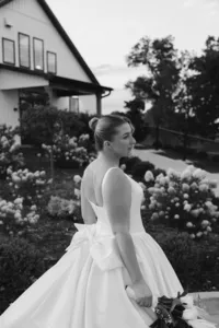 A b&w photo of a bride looking at her husband off frame