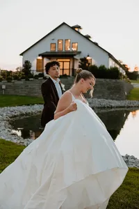 A couple walking along a lake on their wedding day