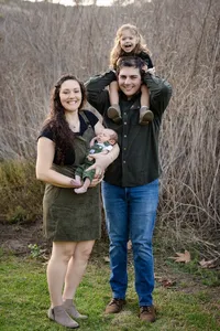 Parents, baby and kid smiling during a fall family photo session in Orange County