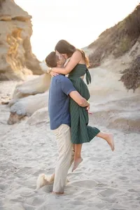 Couple embracing and kissing during an engagement photography session by Lauren Ford Photography in Orange County beach