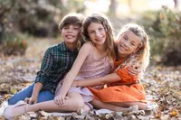Siblings hugging during a natural light outdoor family photography session by Lauren Ford Photography in Orange County