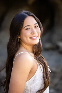 Smiling senior girl during a beach graduation photo session in Orange County