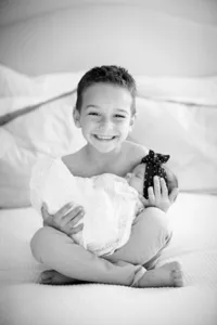 Newborn resting in siblings arms during a lifestyle newborn session in Orange County