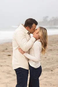 Couple sharing a kiss during an engagement photography session by Lauren Ford Photography in Orange County beach