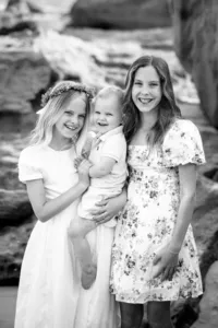 Girls hugging and smiling during a family photo session in Orange County