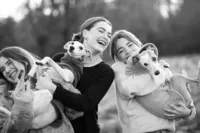 sisters and dogs laughing during an outdoor family photography session by Lauren Ford Photography in Orange County