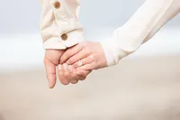 Couples hands and Ring close up during an engagement photography session by Lauren Ford Photography in Orange County beach