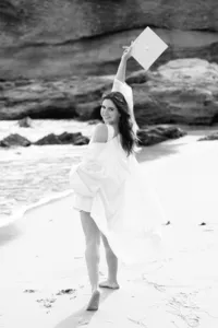 girl smiling at the beach during a graduation photo session in Orange County