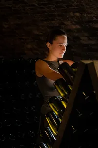Portrait of Alle working with bottles of sparkling wine in the softly lit Bründlmayer cellar.