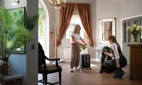 Receptionist welcoming a guest and their dog to the Fox & Hounds Country Hotel in Eggesford, Devon.