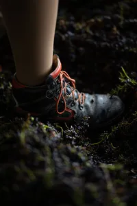 Close-up of a harvest worker's boot among processed grapes and stems during the Bründlmayer grape harvest.
