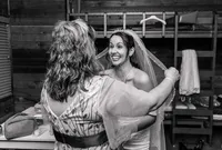 Jacksonville, FL portrait session capturing A bride beams with excitement while her mother-in-law carefully adjusts her veil during a quiet pre-ceremony wedding moment.