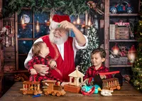 Child watching Santa create holiday magic during a Santa's Workshop photography session in Jacksonville, Florida with Nature's Child Photography, surrounded by handmade wooden toys, festive workshop details, and glowing Christmas wonder in the North Pole workshop.