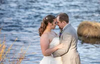 Bride and groom holding each other beside a mountain lake during a wedding photography session in Graeagle, California with Nature’s Child Photography, soft evening light reflecting across the water as the couple shares a quiet moment together.