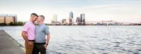 Jacksonville, FL portrait session capturing Engagement capturing a quiet moment between an engaged couple along the riverfront, the city skyline and historic Landing rising in the background.