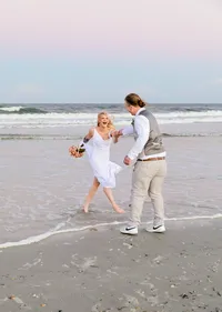 Professional photography by Nature's Child Photography: St. Augustine, wedding capturing a bride laughing as she runs barefoot through the surf toward her groom, waves curling around their feet.