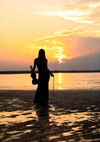 Jacksonville, FL portrait session capturing At sunset along the St. Johns River in Mandarin, a high school senior stands silhouetted in reflective water, holding her violin as golden light stretches across the horizon. (photography by Nature's Child Photography)
