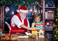 Child smiling as Santa helps him discover a magical toy in Santa's Workshop during a Christmas photography session in Jacksonville, Florida with Nature's Child Photography, surrounded by handmade wooden toys, glowing holiday lights, and festive North Pole workshop details.