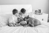 St. Johns newborn capturing a black and white in-home of siblings huddled around their baby sister, the family dog joining in to welcome the newest member. (Photographed by Nature's Child Photography)