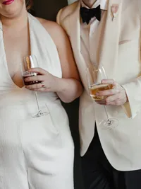 Couple holding wine glasses during their wedding welcome party at Populus Hotel in Denver, Colorado.