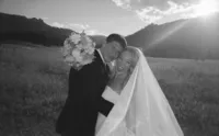 Candid black-and-white film photo of a newlywed couple at Chautauqua Park in Boulder, Colorado.