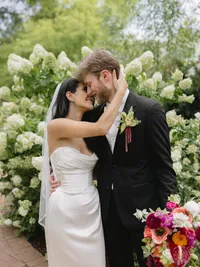 Newlywed couple embracing among white hydrangeas at Denver Botanic Gardens in Colorado.