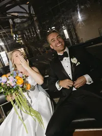 Newlywed couple laughing together on a gondola after their wedding ceremony in Vail, Colorado
