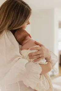 mom-holding-newborn-over-shoulder-cotton-dress-in-home-boulder-photography-103