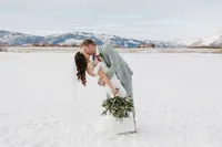 Bride & groom in romantic embrace set against snowy open space at this Granby Ranch in Colorado.