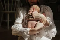 mom-newborn-chest-hold-window-light-white-blouse-in-home-boulder-photographer-273