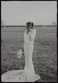 Bride holding a wedding bouquet in a Nebraska countryside setting designed by Roam & Ivy Flowers.