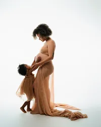 Pregnant mother holding her toddler’s hands during a maternity photoshoot in Atlanta, Georgia.