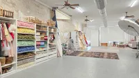 Wide view of Kelsey Freeman’s photography studio with organized props, colorful fabrics, and lighting equipment.