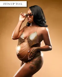 Gold maternity top with thin straps, metallic cup detailing, and decorative chains draped across the bare belly.