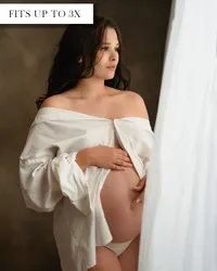 Oversized white cotton button up t-shirt with long sleeves rolled up and buttons undone to reveal the pregnant belly.